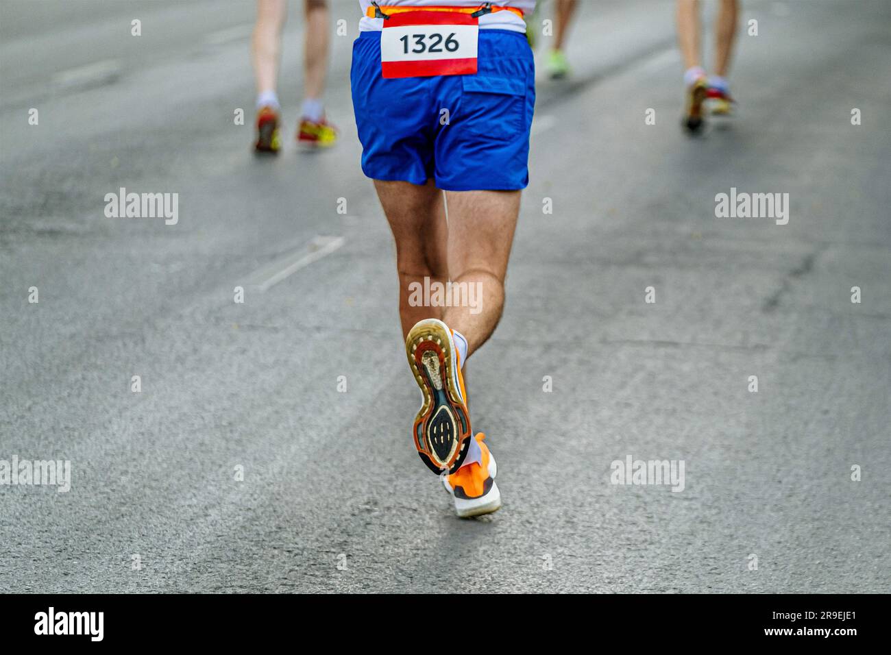 Laufschuhe mit rückwärtiger Sohle Runner Runner Run Marathon-Rennen in grauem Asphalt Stockfoto