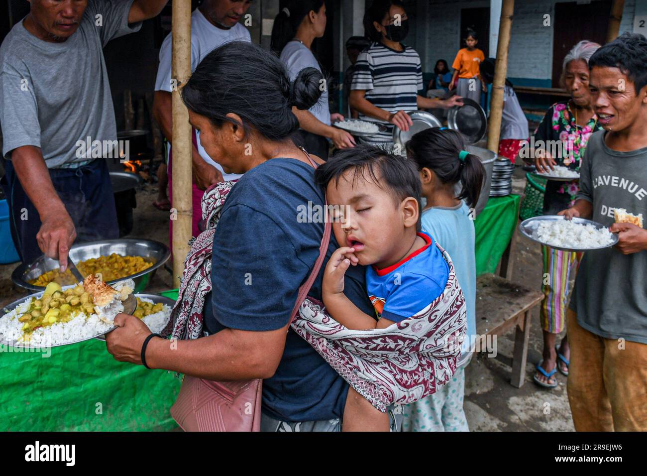 Churachandpur, Indien. 21. Juni 2023. Eine Mutter trägt ihr Kind in einem Hilfslager im Dorf Rengkia. Am 3. Mai 2023 brach im nordöstlichen indischen Bundesstaat Manipur ein ethnischer Konflikt zwischen dem Volk der Meitei, das mehrheitlich im Imphal-Tal lebt, und den Stammesgemeinschaften in den umliegenden Bergen, einschließlich Kuki und Zo, aus. Mindestens 109 Menschen sind bei ethnisch motivierter Gewalt zwischen der Meitei und den Kuki im indischen Bundesstaat Manipur ums Leben gekommen und über 300 wurden verletzt. Kredit: SOPA Images Limited/Alamy Live News Stockfoto