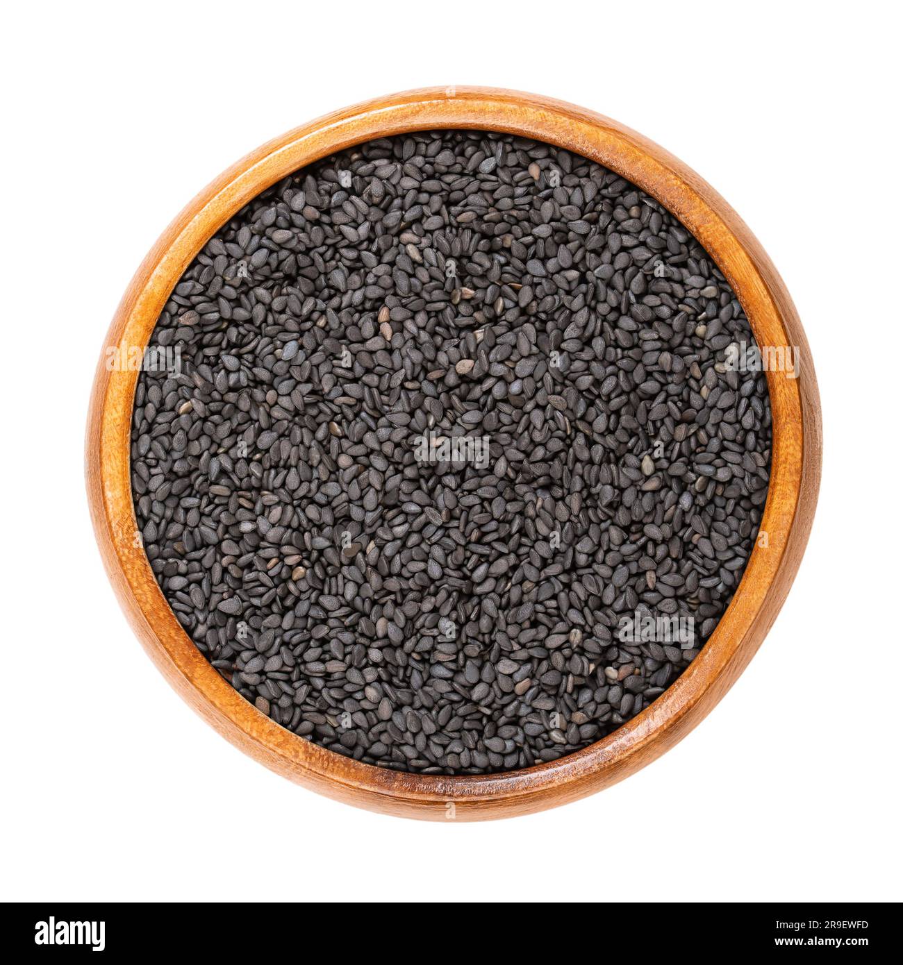 Schwarzer Sesam, in einer Holzschüssel. Nicht hüllte Samen von Sesamum indicum, mit reichem und nussigem Geschmack und mit einem der höchsten Ölgehalte aller Samen. Stockfoto