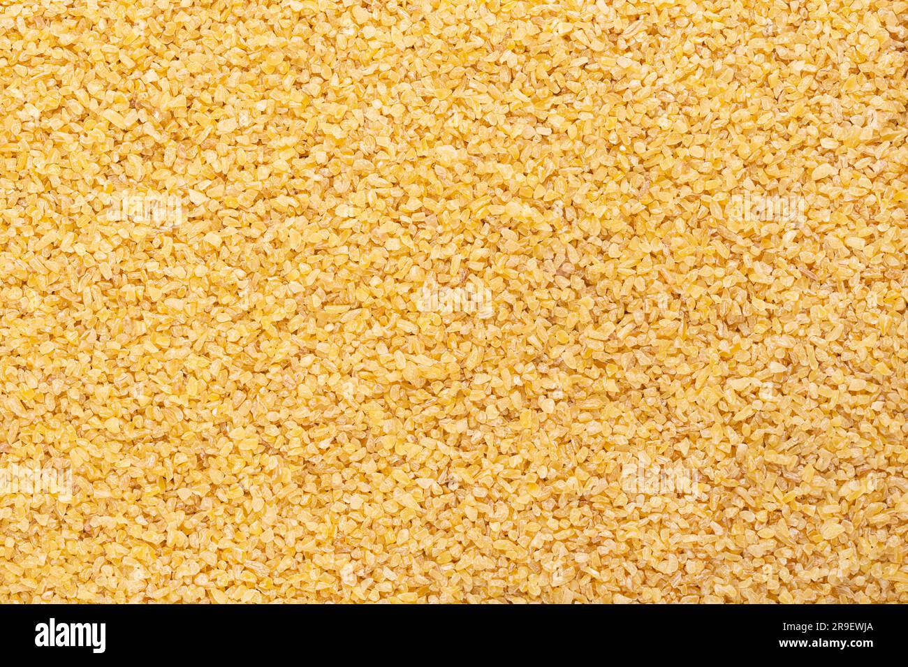 Grobes Bugur, auch Burghul genannt, Oberfläche, von oben. Weizenfuttermittel mit Riss- und Parboiled und gängige Zutat in der Küche Westasiens. Stockfoto