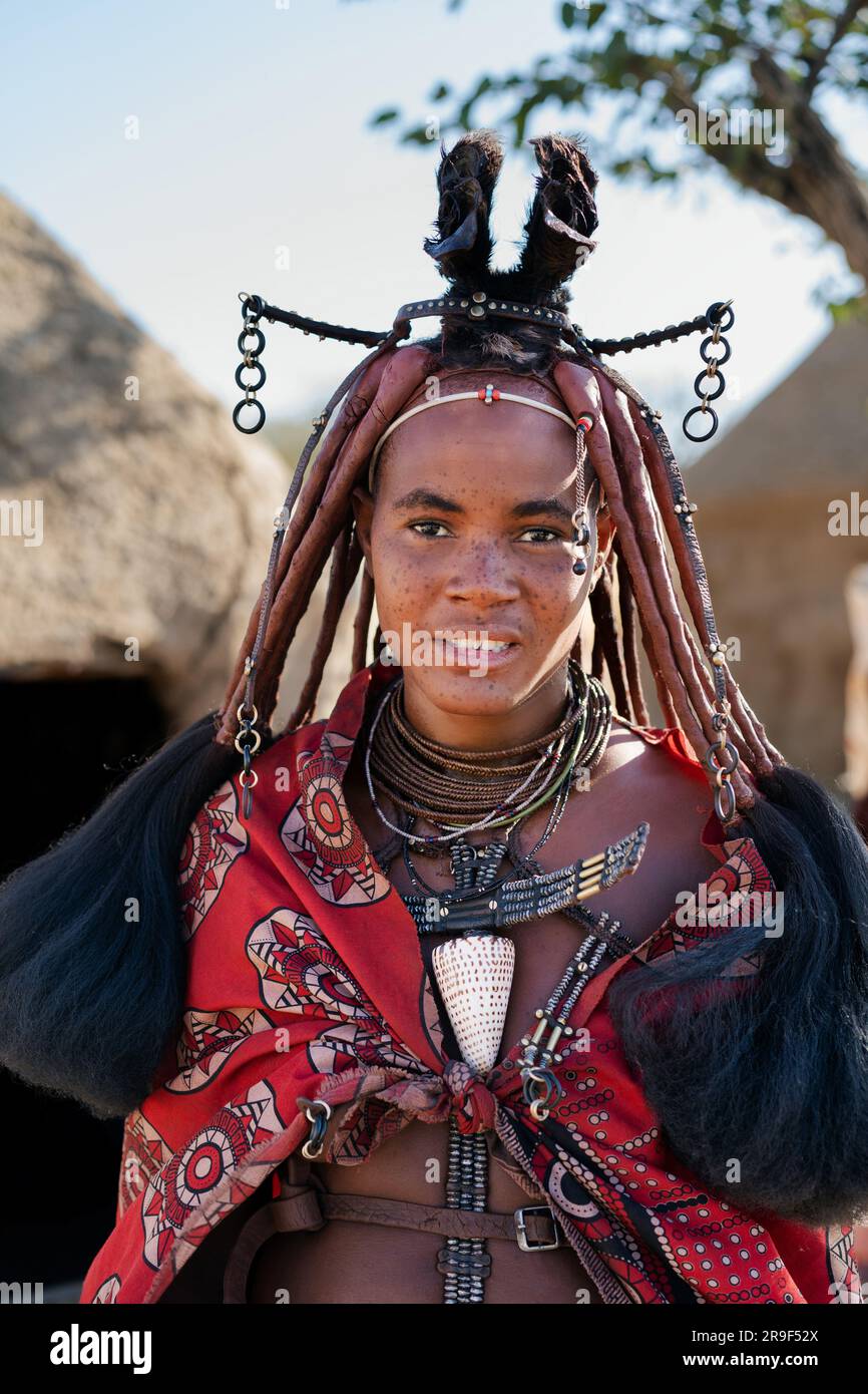 Himba-Frau in traditionellem Stil gekleidet in ihrem Dorf in der Nähe von Kamanjab in Namibia, Afrika. Stockfoto