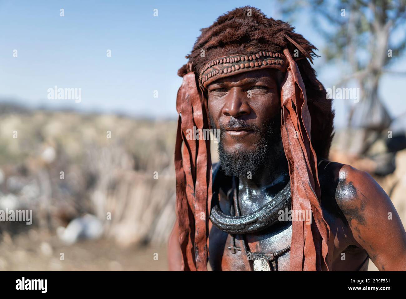 Himba-Mann in traditionellem Stil gekleidet in seinem Dorf in der Nähe von Kamanjab in Namibia, Afrika. Stockfoto