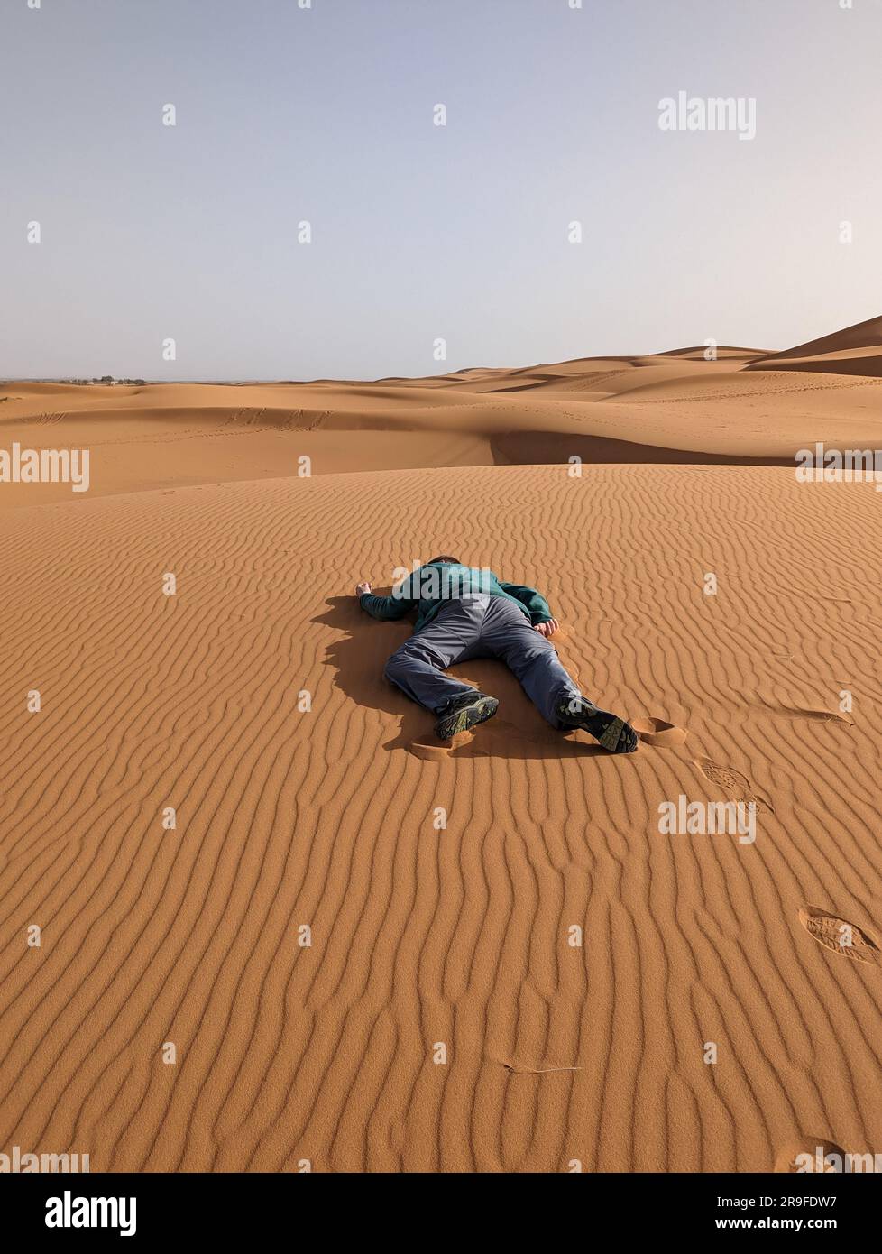 Eine Person, die vorgibt, tot in der Erg Chebbi Wüste in Marokko zu liegen Stockfoto