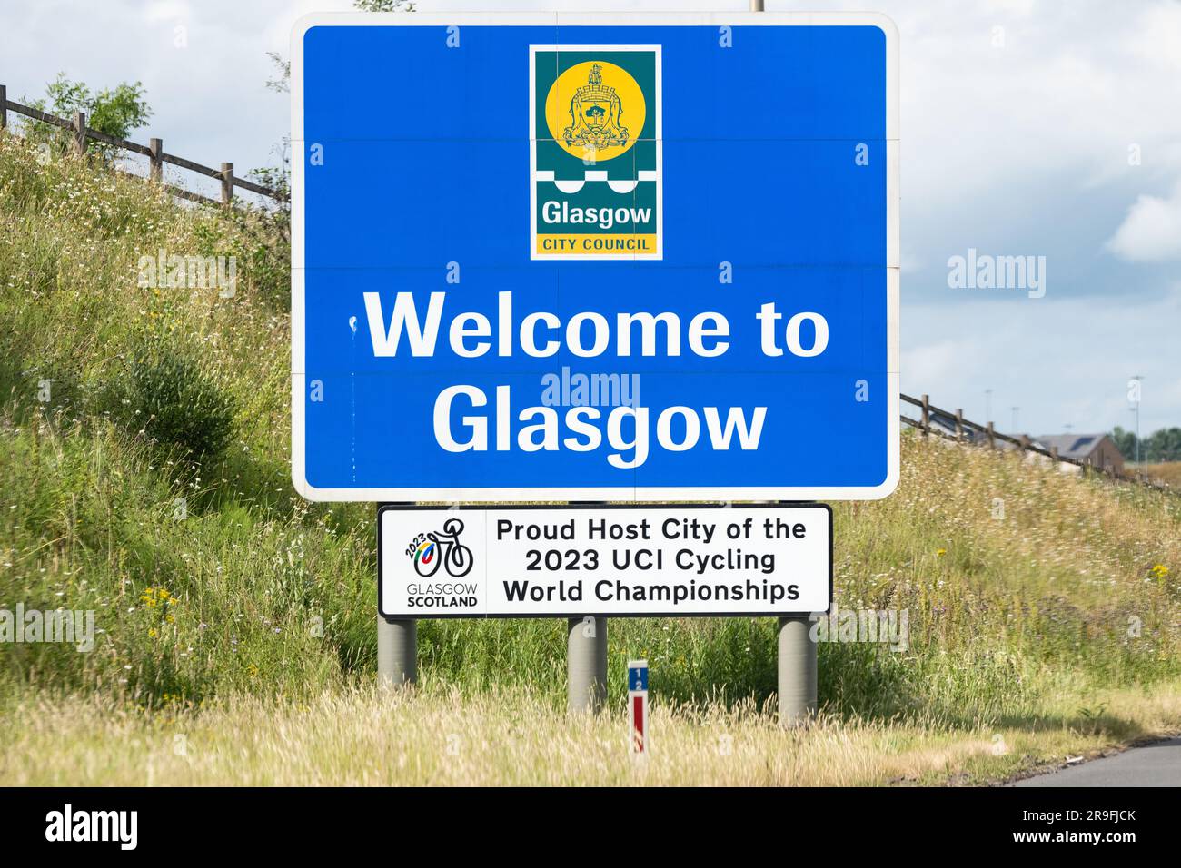 Das Schild „Welcome to Glasgow“ auf der Autobahn M8, Glasgow, Schottland, Großbritannien, ist dem „Proud Host City of the UCI Cycling World Championships 2023“ beigefügt Stockfoto