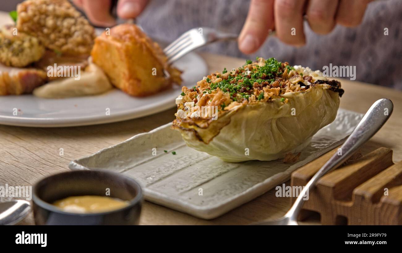 Gegrillter Hispi-Kohl mit Salatcreme und knusprigem Schweinefleisch Stockfoto