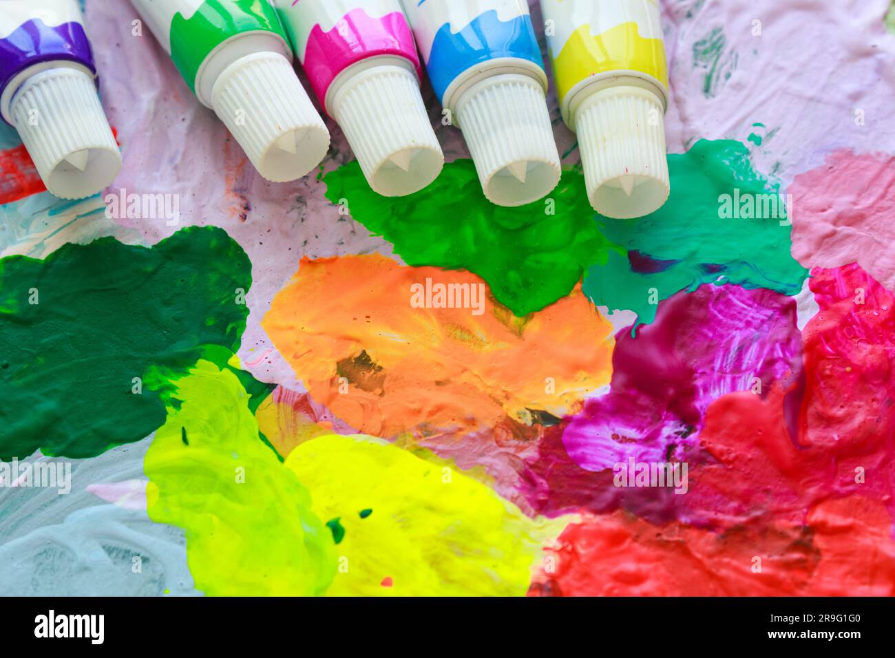 Farbtupfer vor dem Hintergrund einer hellen mehrfarbigen Farbpalette der Nahaufnahme des Künstlers. Stockfoto