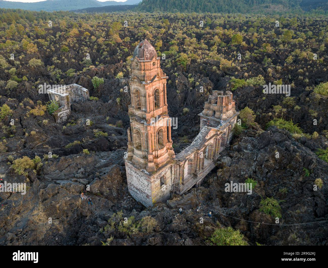 Die Ruinen des Vulkans Paricutin liegen auf einer felsigen Landschaft, umgeben von üppigem Grün Stockfoto