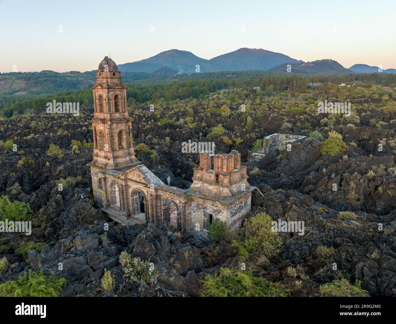 Die Ruinen des Vulkans Paricutin liegen auf einer felsigen Landschaft, umgeben von üppigem Grün Stockfoto