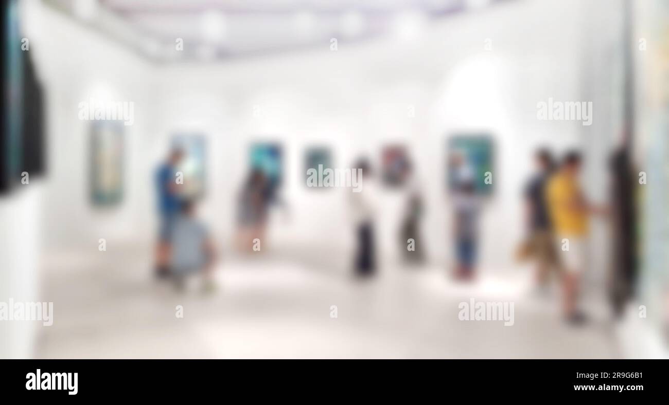 Kunstgalerie verschwommener Hintergrund und Menschen, die Gemälde an weißen Wänden betrachten. Stockfoto