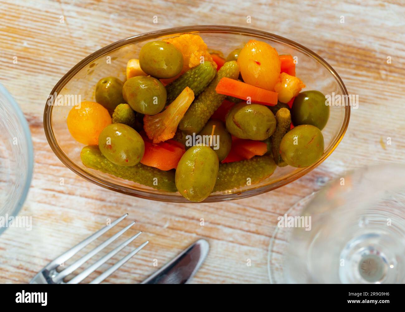 Grüne Oliven serviert mit Gurke, Karotte, Knoblauch und Zwiebeln Stockfoto