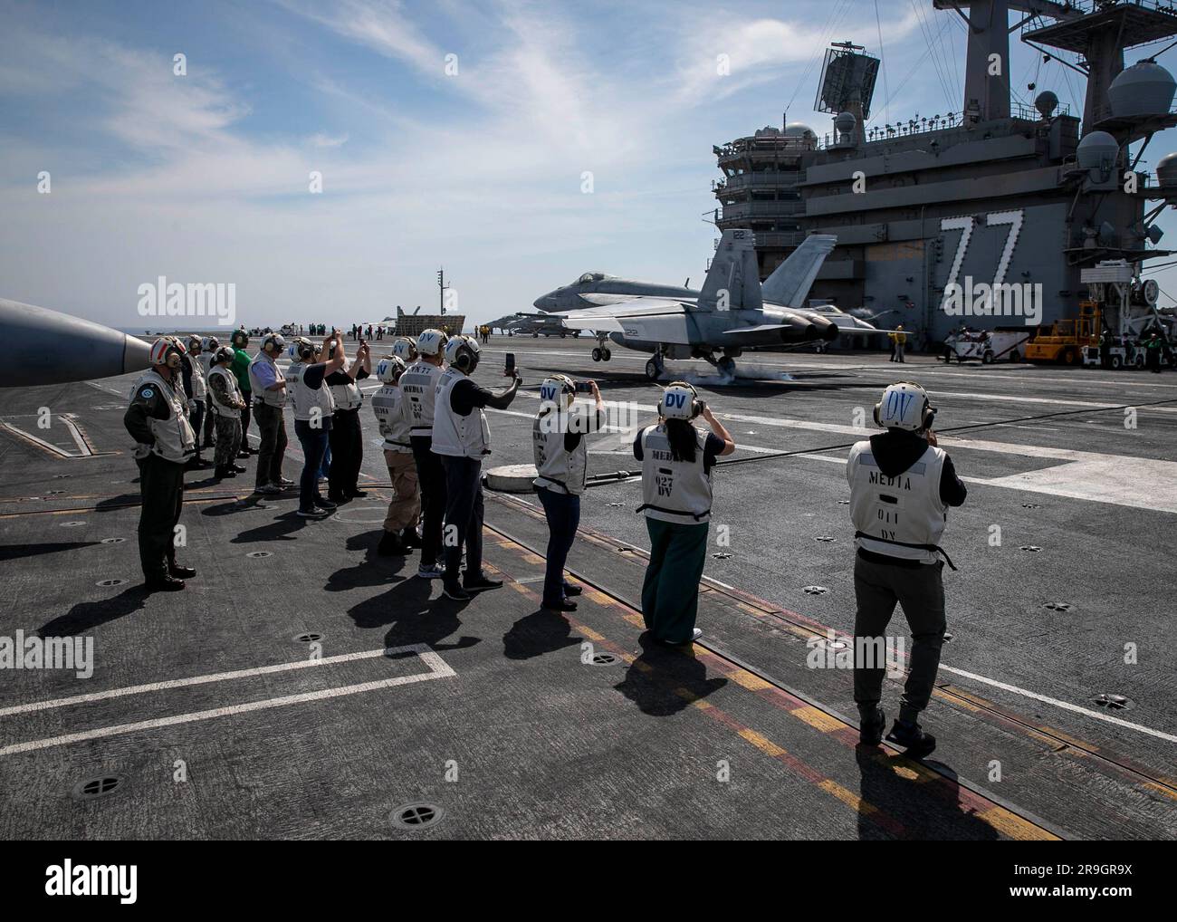 230624-N-EL850-2129 ATLANTISCHER OZEAN (24. Juni 2023) Militär, Religion und Branchenführer beobachten eine F/A-18E Super Hornet, die an Strike Fighter Squadron (VFA) 106 befestigt ist und auf dem Cockpit des Flugzeugträgers USS George H.W. der Nimitz-Klasse landet Bush (CVN 77), 24. Juni 2023. Die George H.W. Bush ist im Atlantik dabei, Carrier-Qualifikationen zu absolvieren, eine Fortbildung, die die Kompetenz der Piloten sicherstellt. (USA Marinebild von Mass Communication Specialist 3. Class Nicholas Avis) Stockfoto