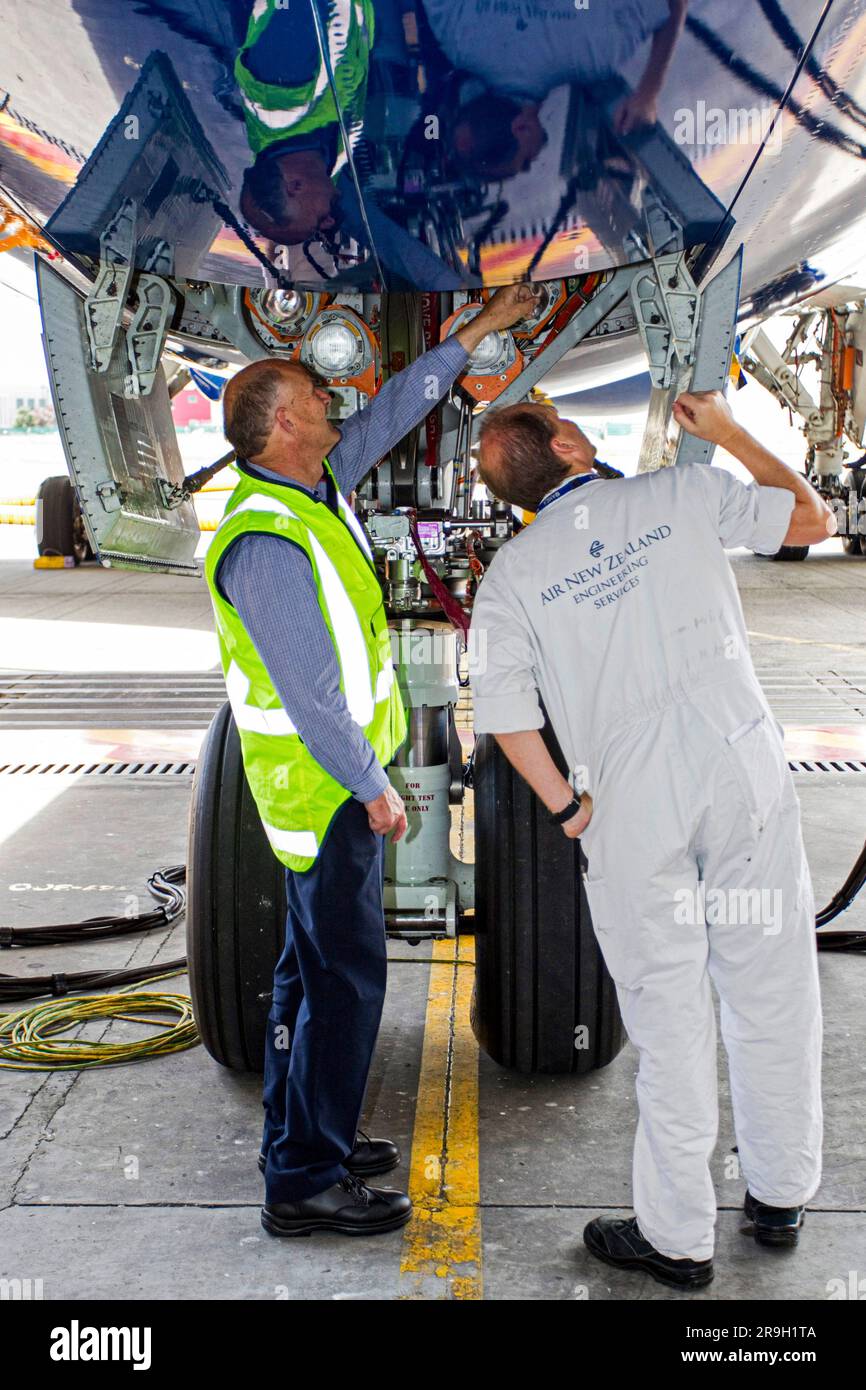 Die Ingenieure inspizieren das Laufwerk beim ersten Test mit einem Flugzeug des Typs Boeing 787 Dreamliner, das die südliche Hemisphäre als Gäste von Air New Zealand besucht. Stockfoto
