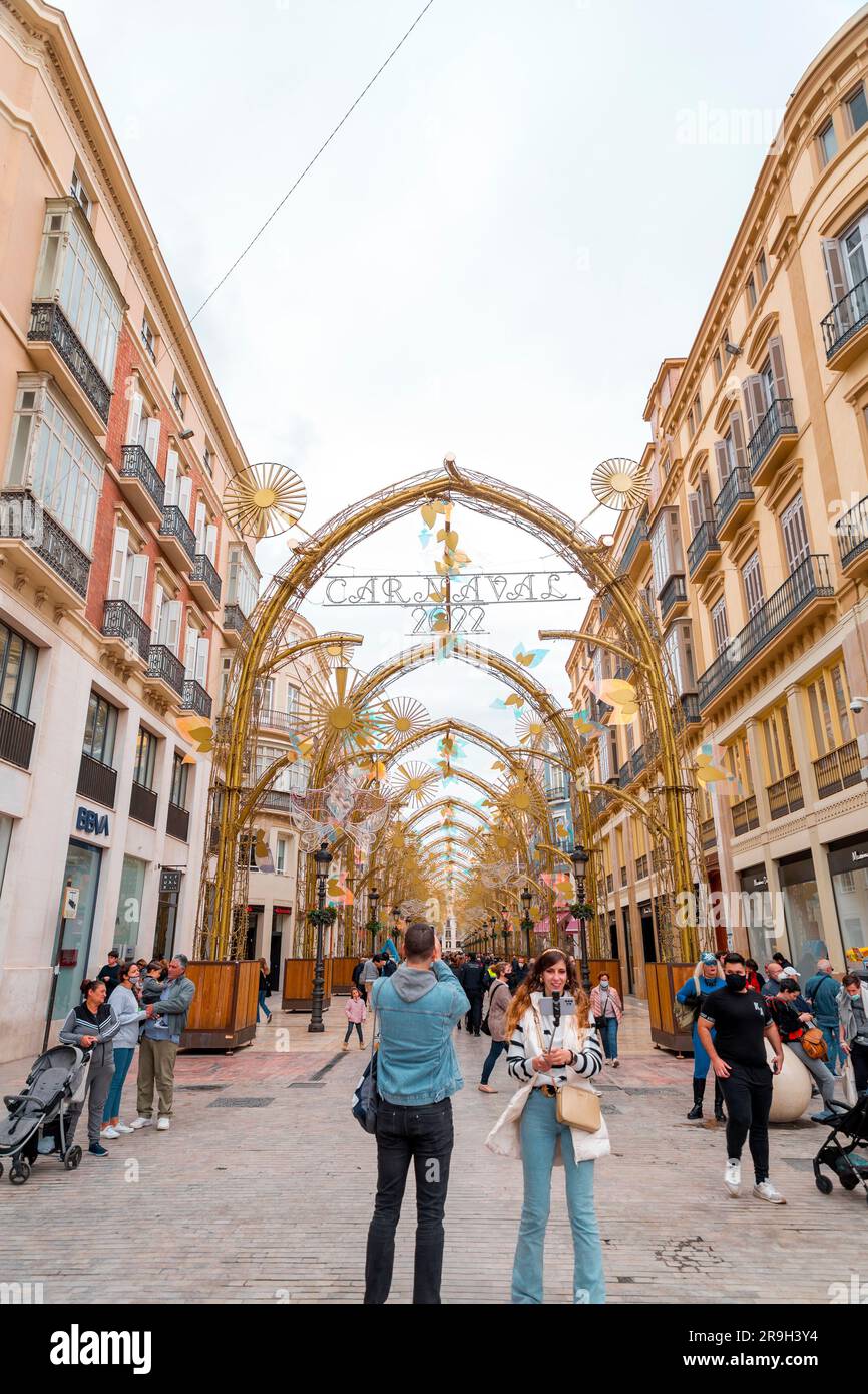 Malaga, Spanien - 27. FEBRUAR 2022: Marques de Larios Street, eine lebhafte Einkaufsstraße in Malaga. Es ist im Februar 22 mit Karnevalsschmuck dekoriert. Stockfoto