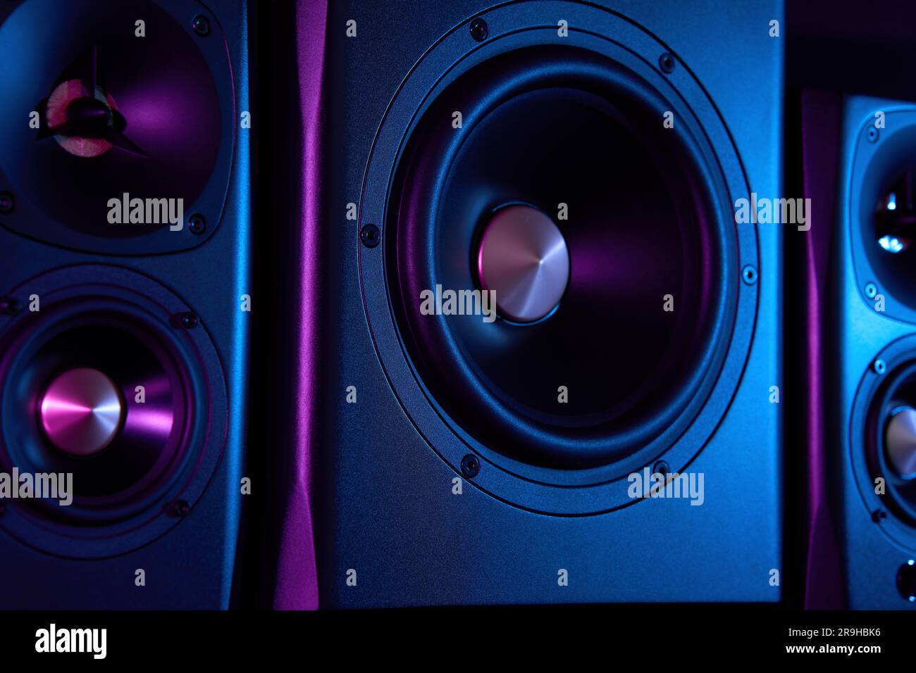 Akustische Multimedia-Lautsprecher mit Neonbeleuchtung. Sound-Audiosystem mit zwei Satelliten und Subwoofer auf dunklem Hintergrund. Stockfoto