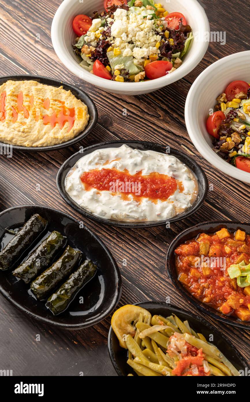 Gemischte türkische Vorspeisen auf Holztisch. Türkischer Mezze. Zum Beispiel gefüllte Blätter, Humus Stockfoto