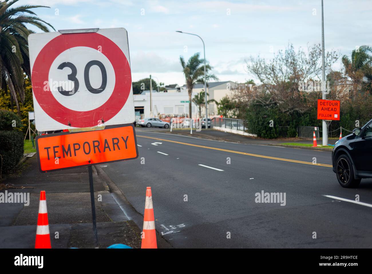 Temporäres 30km-Geschwindigkeitsbegrenzungsschild und Umleitungsschild am Straßenrand. Straßenarbeiten auf Auckland Road. Stockfoto