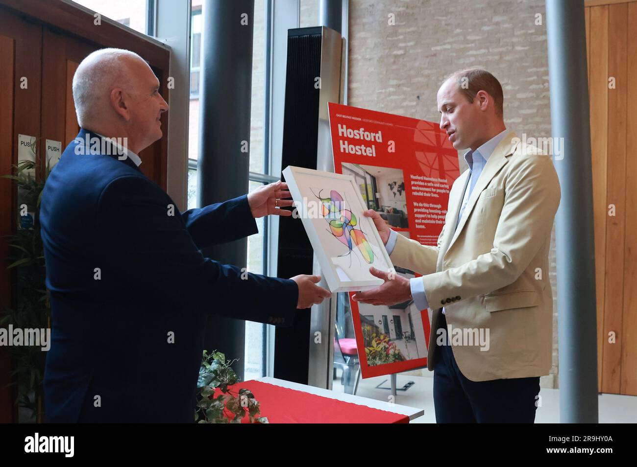 Der Prinz von Wales erhält ein Geschenk von Reverend Brian Anderson bei einem Besuch der Mission East Belfast im Skainos Centre, Belfast, im Rahmen seiner Reise durch Großbritannien, um ein Projekt zur Beendigung der Obdachlosigkeit einzuleiten. Foto: Dienstag, 27. Juni 2023. Stockfoto