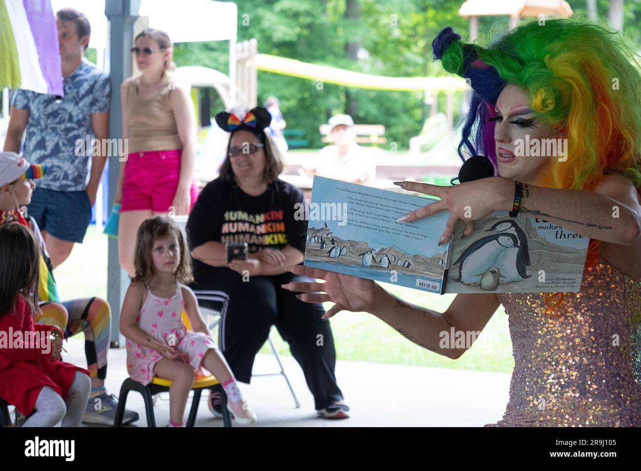 Ein Drag Performer liest ein Buch zu Kindern mit dem Namen Einpassen, über Inklusivität. In Lewisboro, Westchester, bei einer Pride-Veranstaltung. Juni 2023. Stockfoto