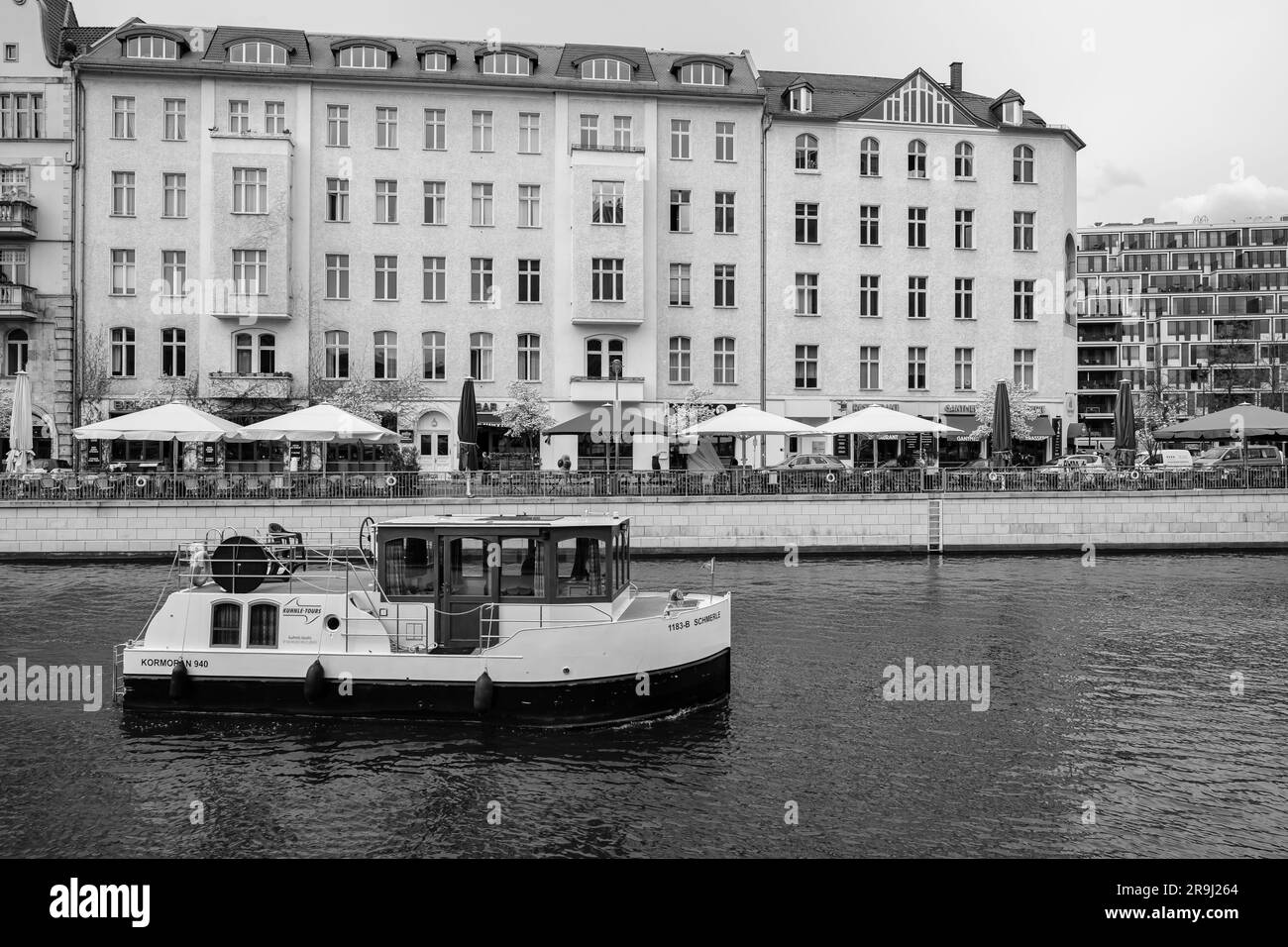 Berlin, Deutschland - 19. April 2023 : Blick auf ein kleines Boot und verschiedene Restaurants im Hintergrund an der Spree in Berlin Stockfoto