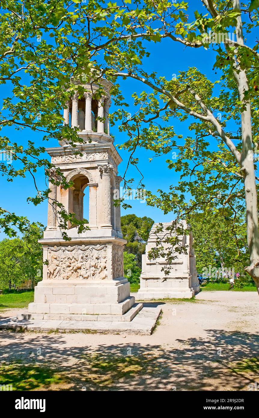Die schattigen Sycamore-Bäume umgeben die archäologische Stätte Les Antiques (die Antiquitäten) mit antiken Wahrzeichen der römischen Stadt Glanum - dem Mausoleum A. Stockfoto