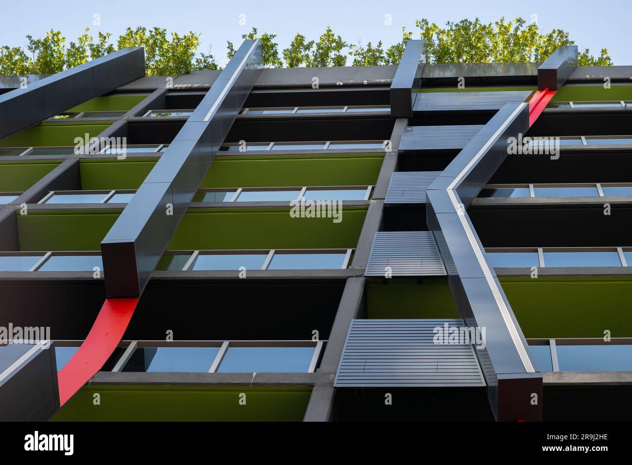 Ein Blick auf die Straße von einem postmodernen Gebäude mit hellen Farben und abgewinkelten Metallrohren. Stockfoto