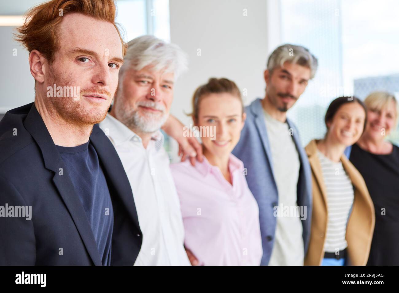 Selbstbewusstes Business-Team, das Arme umeinander hat Stockfoto
