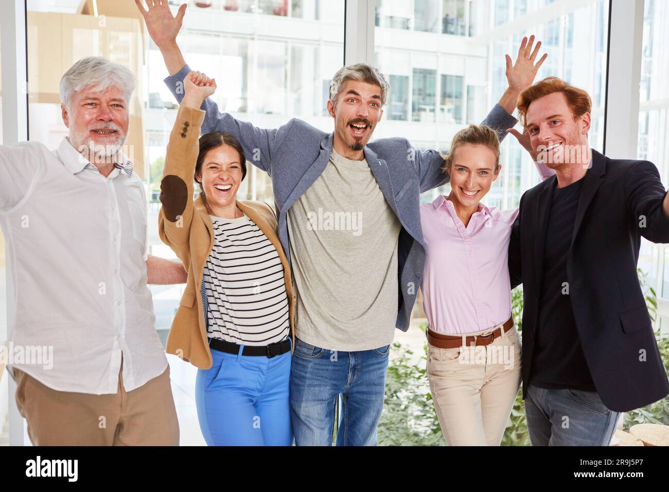 Porträt von fröhlichen männlichen und weiblichen Profis gegen Fenster Stockfoto