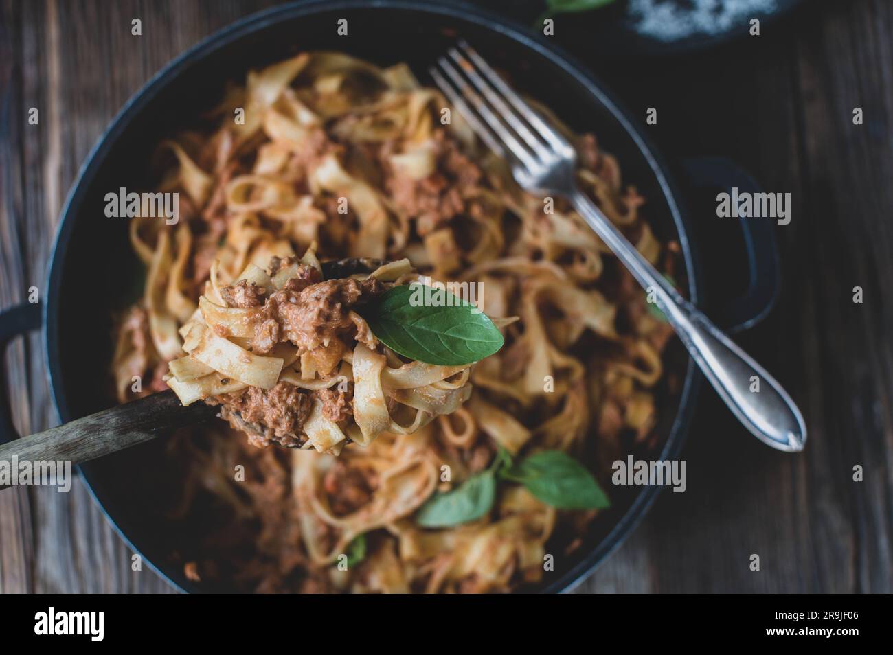 Pasta mit Thunfisch in einer köstlichen Tomatensauce und Parmesankäse auf Holzlöffel Stockfoto
