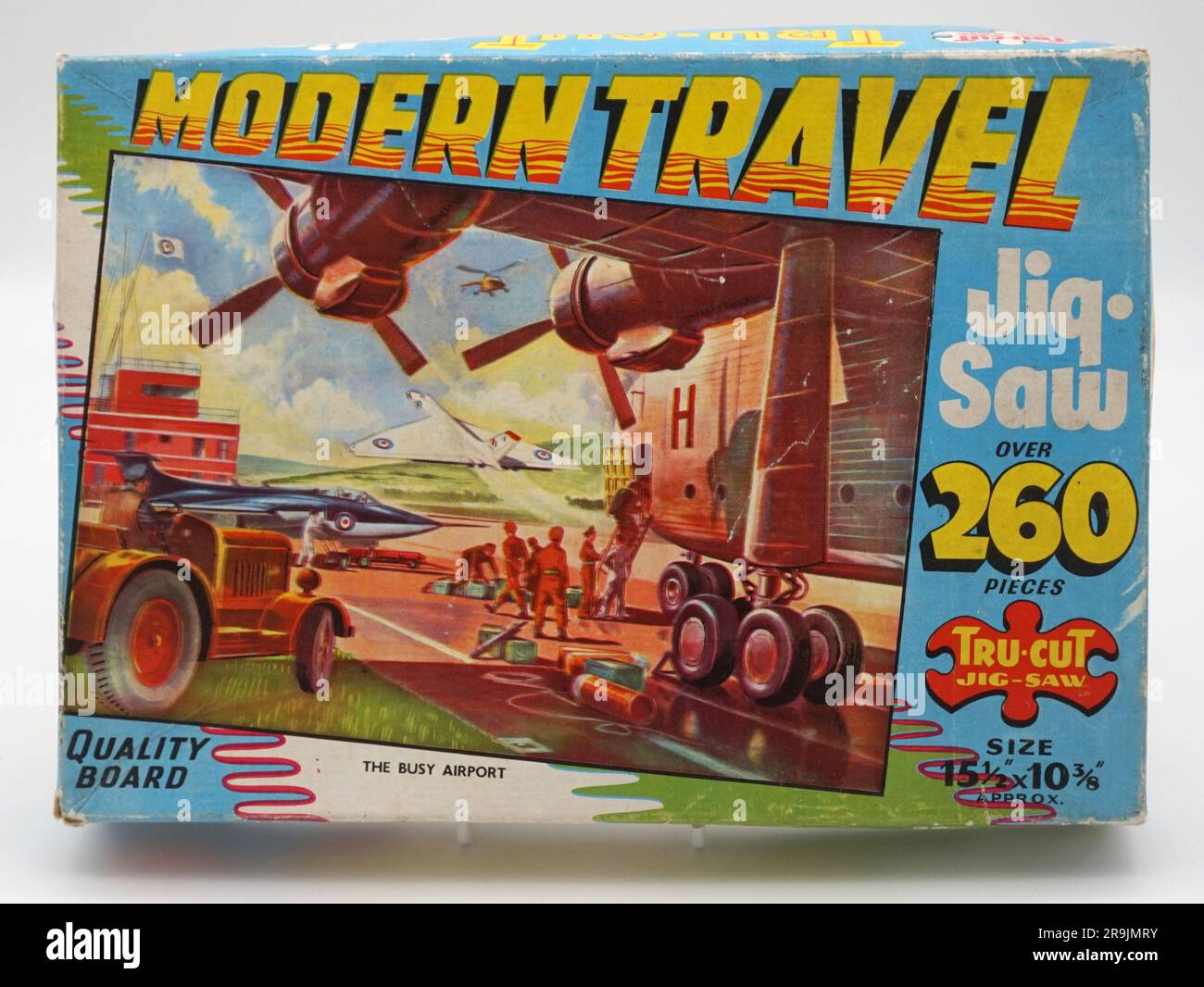 Modern Travel Tru-Cut Jig sah Puzzle der geschäftige Flughafen. Ein wirklich atmosphärisches Gemälde, das eine Reihe historischer Flugzeuge zeigt, darunter ein großes Transportflugzeug, die Blackburn Beverley, die geladen werden. In der Nähe befindet sich ein RAF-Javelin-Jet und ein vulkanischer Bomber, der abhebt. Verschiedene Bodenbesatzungen sind bei der Arbeit beschäftigt. Die Abbildung ziert eine helle und luftige Box mit handgezeichneten Schriften in verschiedenen Stilen und einem tollen, schrägen Modern Travel Logo. Ausgestellt in den späten 1950er Jahren Stockfoto