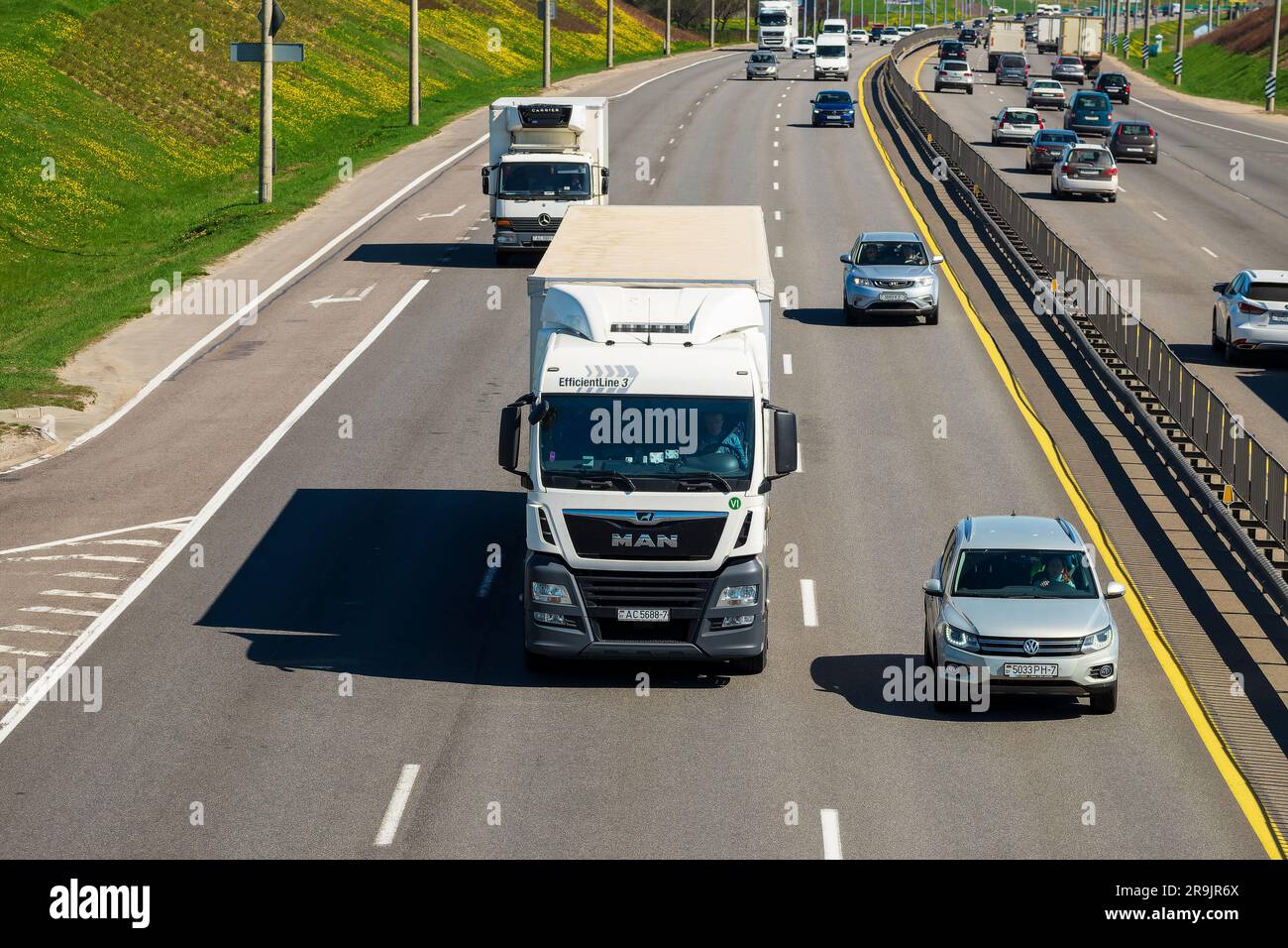 Minsk, Belarus - 10. Mai 2022: Eine Straße mit starkem Verkehr in beide Richtungen. Im Vordergrund befindet sich ein großer Lkw. Vorderansicht Stockfoto