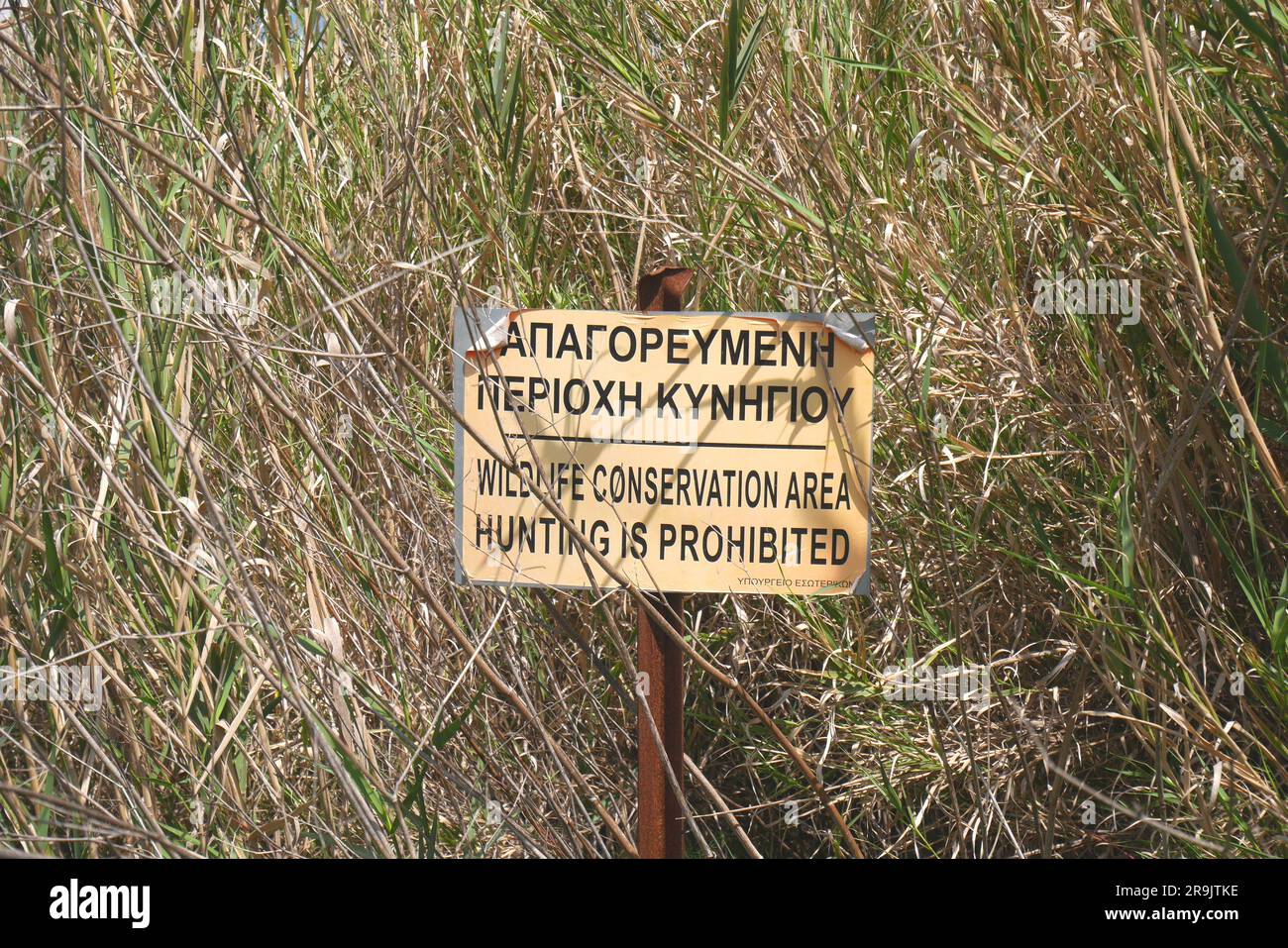 Schild auf Griechisch und Englisch mit der Aufschrift Wildlife Conservation Area Hunting is Verboted, Episkopi, near Paphos, Republik Zypern Stockfoto