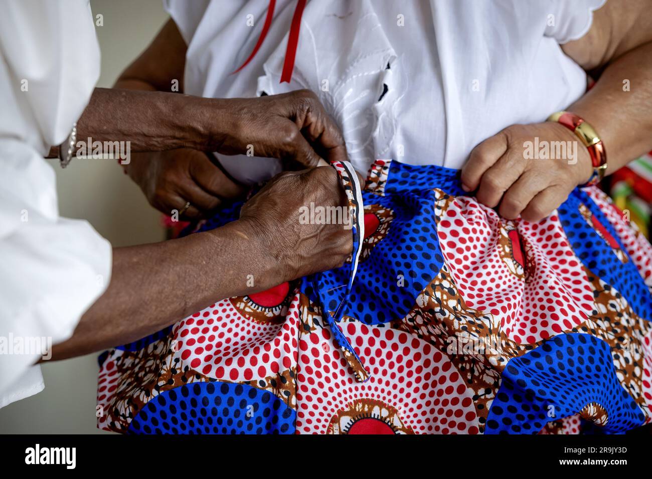 AMSTERDAM - Shirley während der Anprobe bei Oma Rinia Overman (l) des Koto, einem traditionellen Kleidungsstück kreolischer Frauen in Suriname, im Vorfeld von Keti Koti. Am 1. Juli wird es 160 Jahre her sein, dass die Niederlande beschlossen haben, die Sklaverei abzuschaffen, und vor 150 Jahren wurden die letzten versklavten Menschen frei. ANP ROBIN VAN LONKHUIJSEN niederlande raus - belgien raus Stockfoto