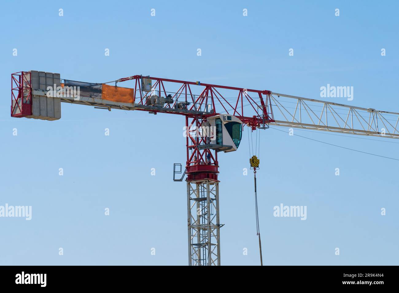 Rot weiß gestrichener Turmkran vor dem blauen Himmel Stockfoto