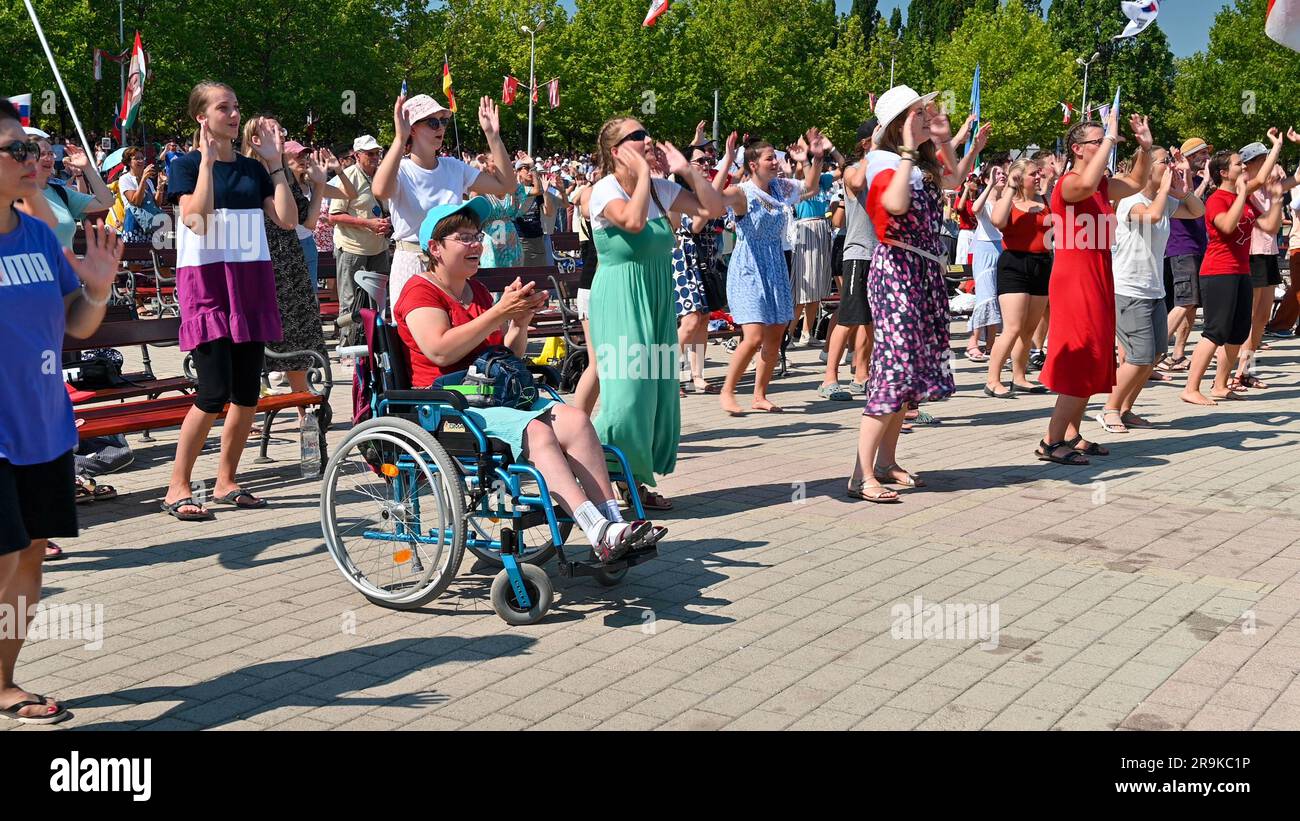 Junge Menschen tanzen zu christlichen Liedern während des Mladifests 2022 – dem Jugendfestival – in Medjugorje. Unter ihnen eine Frau im Rollstuhl. Stockfoto