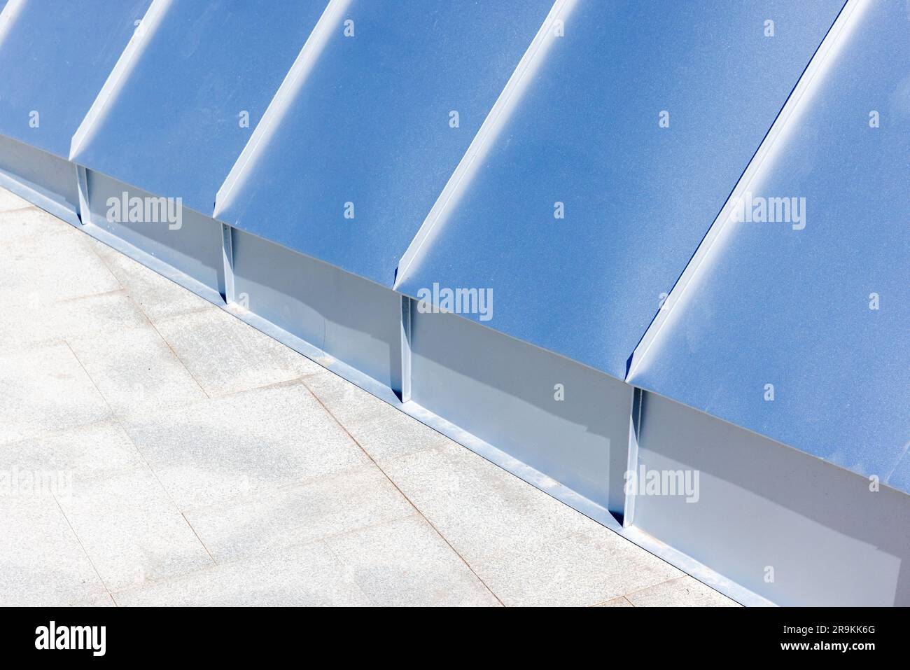 Hintergrundfoto abstrakter Architektur mit neuem glänzendem Dach aus Edelstahlplatten und Bodenfliesen aus Stein Stockfoto