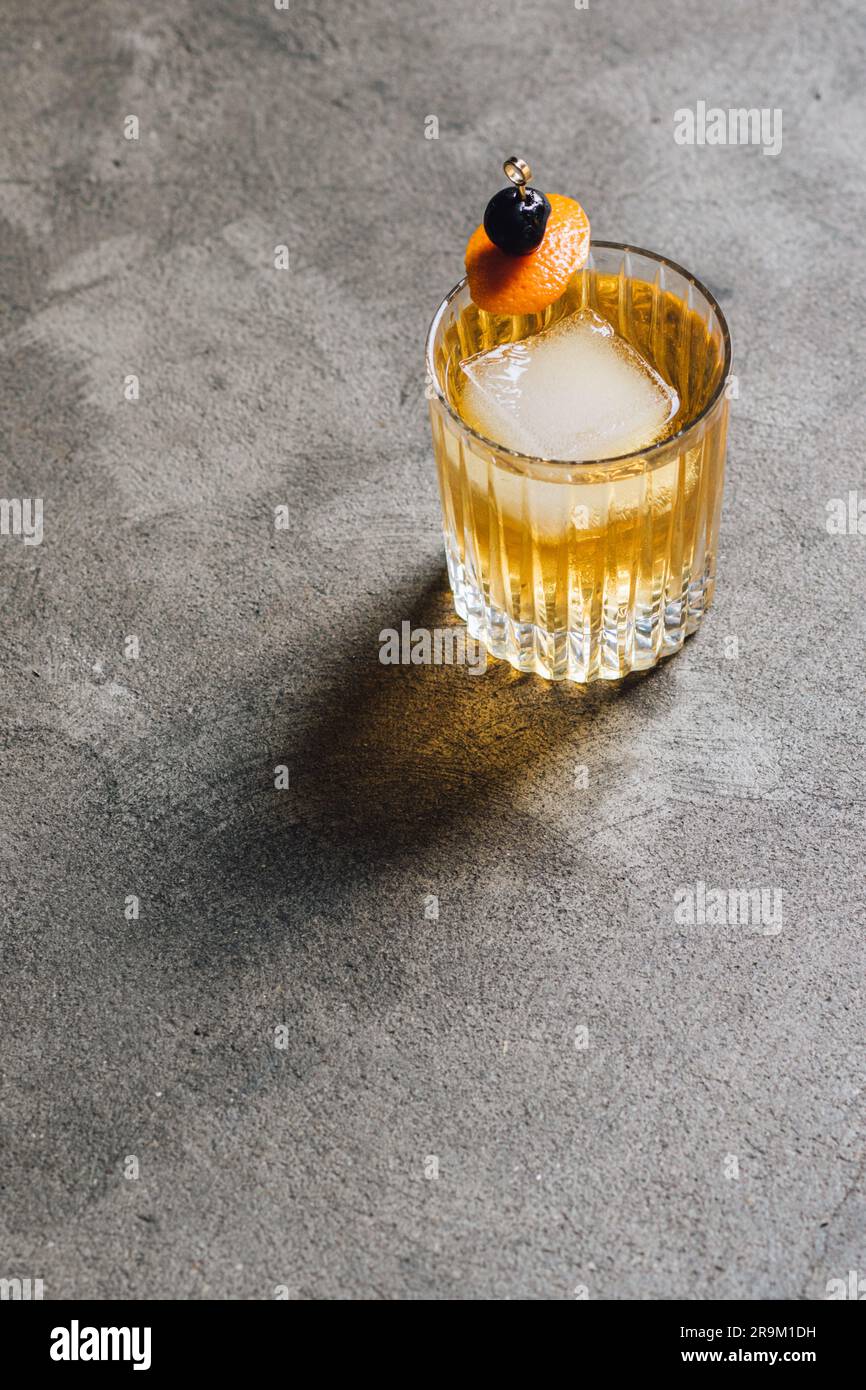 Whiskey-Soda-Highball-Cocktail in doppelt altmodischem Glas mit Orangen- und Kirschgarnierung Stockfoto