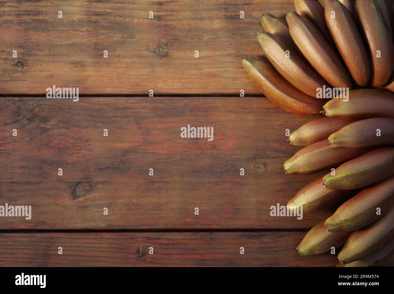 Leckere lila Bananen auf einem Holztisch, Blick von oben. Platz für Text Stockfoto