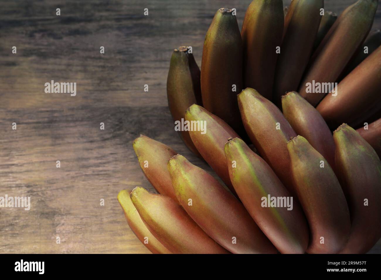 Leckere lila Bananen auf einem Holztisch, Blick von oben. Platz für Text Stockfoto
