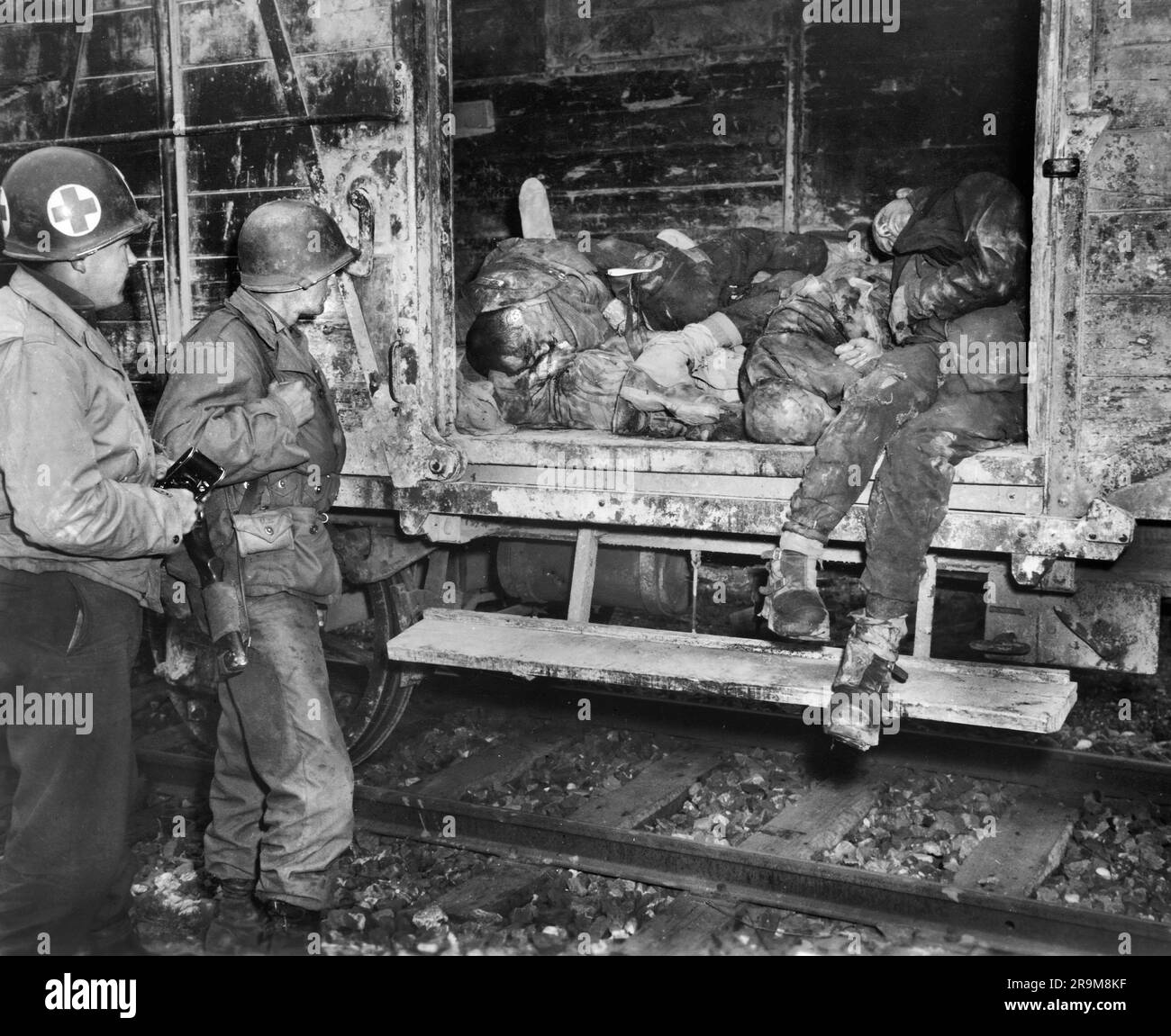 Zwei US-Soldaten beobachten tote Gefangene im Eisenbahnzug im unidentifizierten Konzentrationslager, Deutschland, USA Army Signal Corps, 1945. April Stockfoto