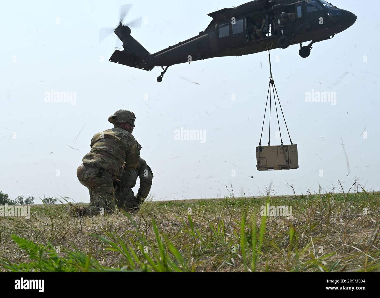 USA Preston Martin und Dalton Waldo, Spezialisten der Nationalgarde der Armee, Mitglieder der 142. Engineer Battalion Forward Support Company (FSC), überwachten eine Last mit UH-60-Ausrüstung für Agile Combat Employment (ACE)-Transporte zu Trainingszwecken während der Ausübung des Gewaltmonopols in Camp Grafton bei Devils Lake N.D., 13. Juni 2023. Das Gewaltmonopol 2023 hat die Fähigkeit des Flügels, Truppen und Fracht über eine militärische Luftbrücke zu entsenden und umzuschichten, um die Integration mehrerer Einheiten zu ermöglichen, erschlossen. (USA Air National Guard – Foto von Senior Airman Christa Anderson) Stockfoto