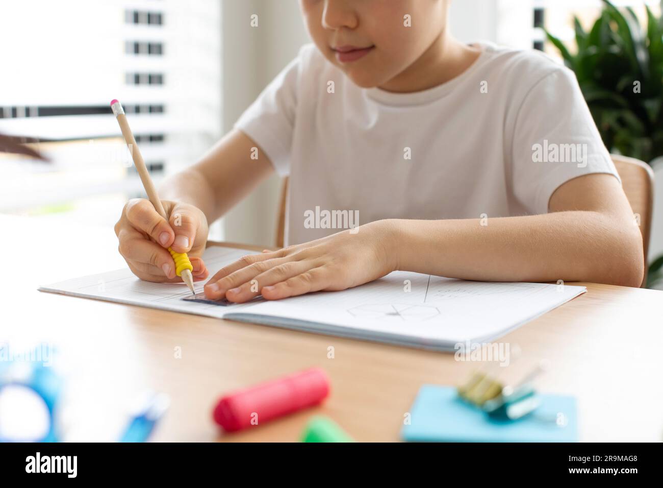 Ein süßer Junge zeichnet mit Lineal und Bleistift. Hausunterricht. Geometrie und Zeichnung. Stockfoto