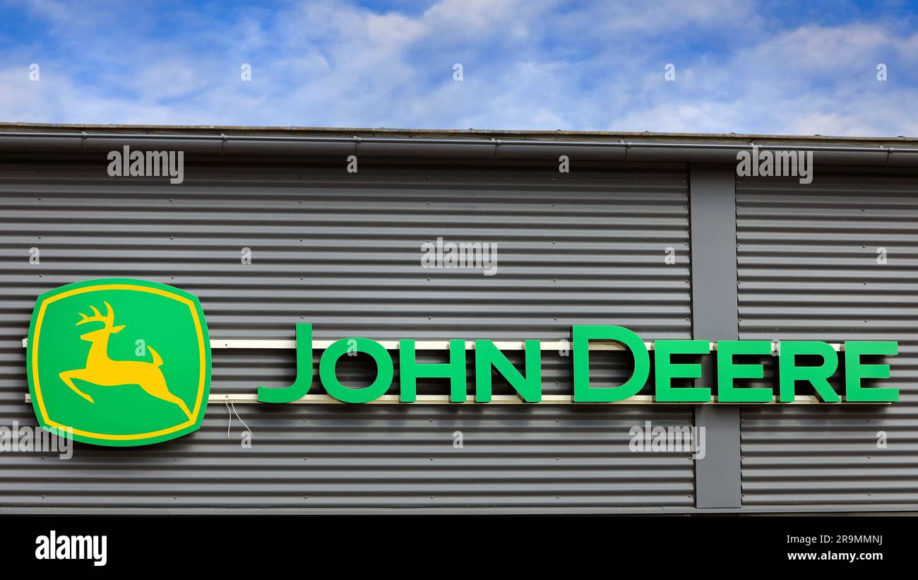 John Deere Logo außen am Gebäude mit blauem Himmel und Wolken. Salo, Finnland. 25. Juni 2023. Stockfoto