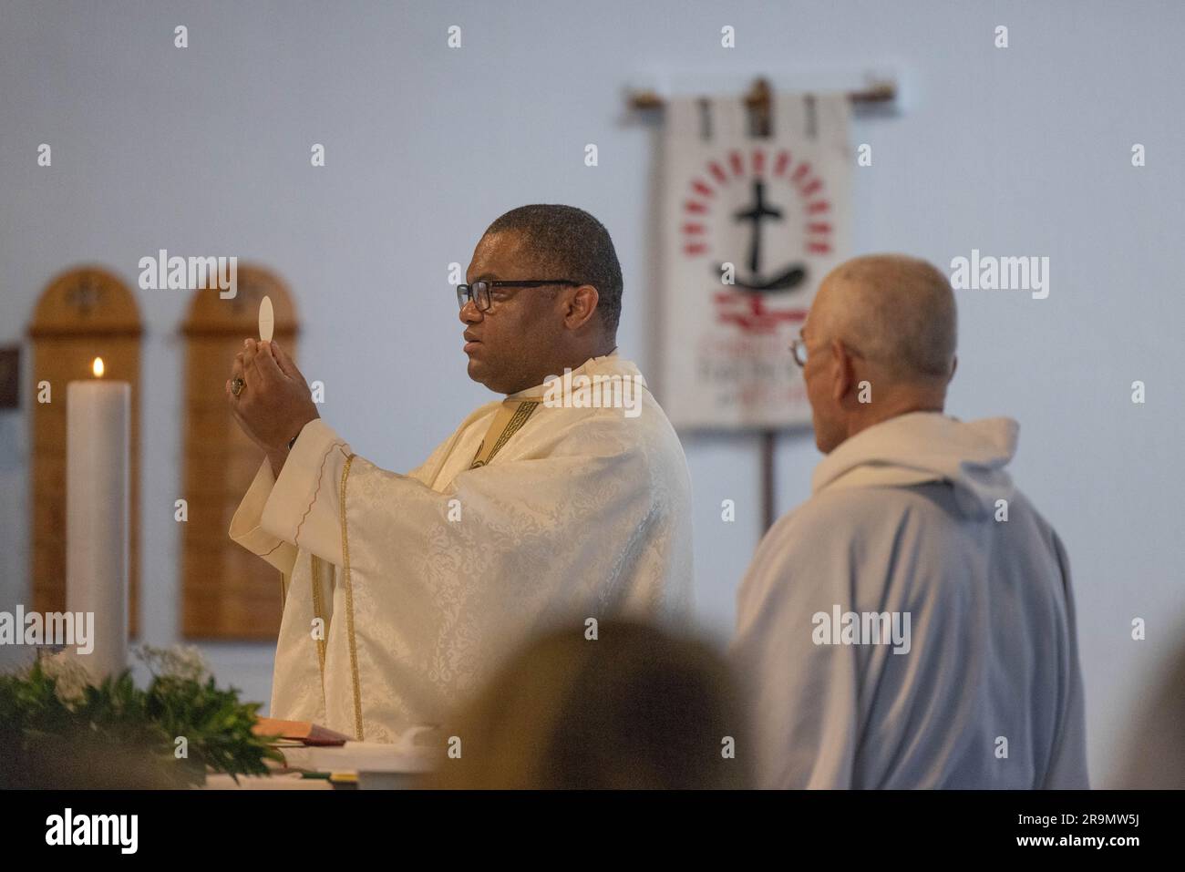 Der katholische Priester bereitet während der Messe die eucharistische Heilige Kommunion vor Stockfoto