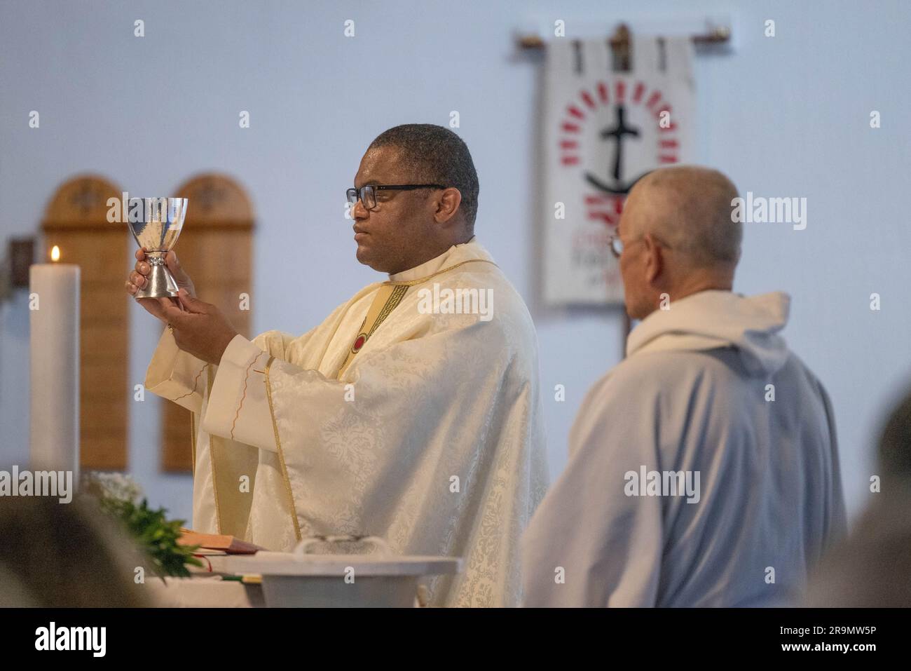 Der katholische Priester bereitet während der Messe die eucharistische Heilige Kommunion vor Stockfoto