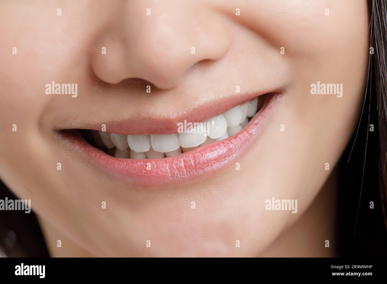 Nahaufnahme einer lächelnden Asiatin, die ihre schönen weißen Zähne mit Kopierbereich zeigt Stockfoto