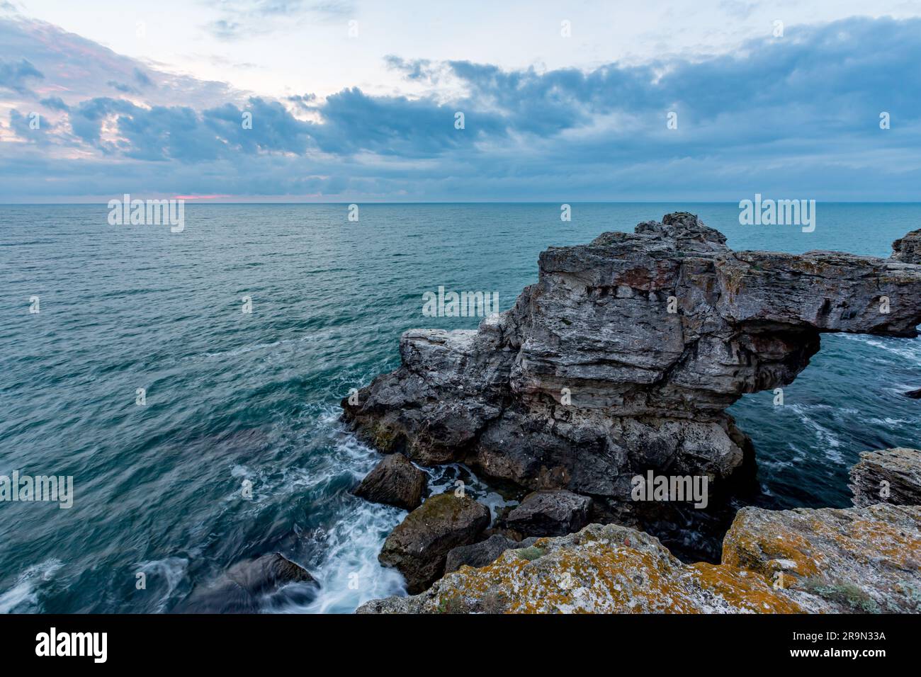 Malerische Felsformationen im Meer, die wie ein Bogen geformt sind. Schwarzes Meer, Nordosten Bulgariens, in der Nähe des Dorfes Tyulenovo, Blue Hour Stockfoto