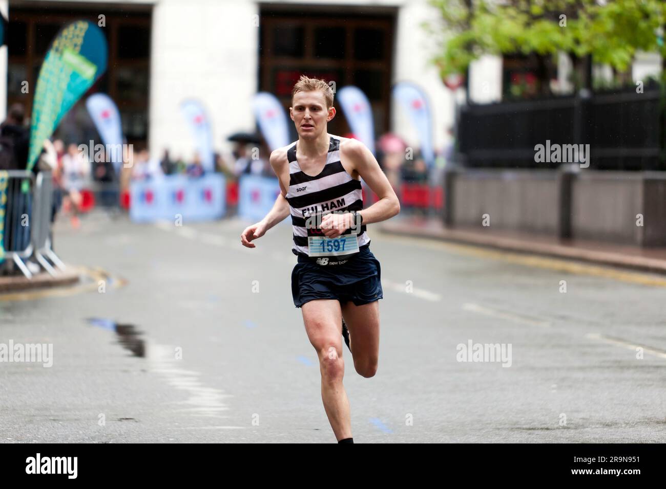 Charlie Sandison (GBR) fährt durch Cabot Square, auf dem Weg zum Ziel 6. in der Mass 18-39 Kategorie, 2023 London Marathon in einer Zeit von 02:19:22. Stockfoto