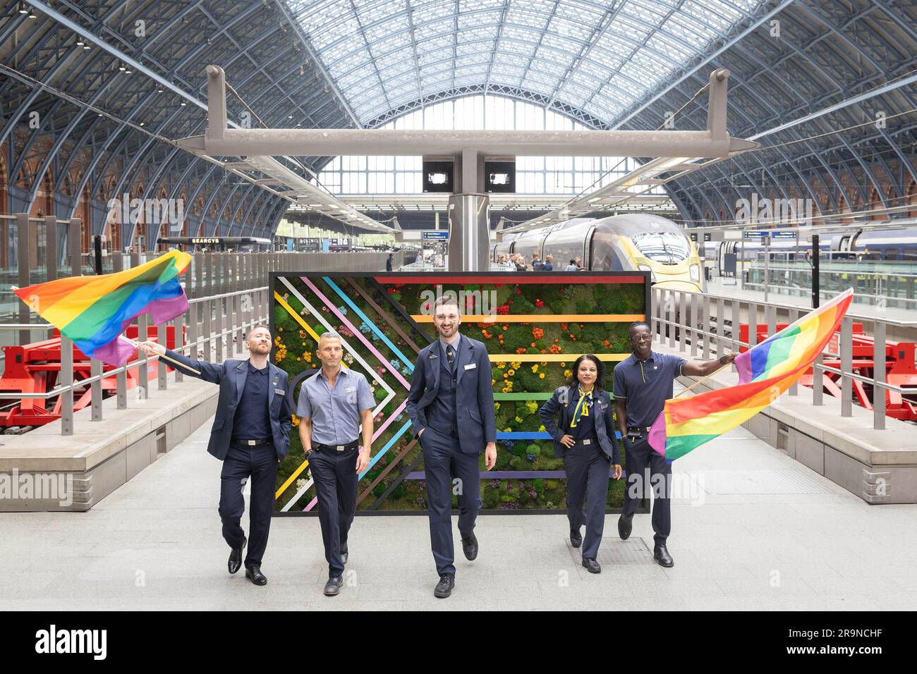 NUR ZUR REDAKTIONELLEN VERWENDUNG (von links nach rechts) Guillaume Baudoin, Jerome Charles, Benoit Couillet, Artie Ramdharry und Jules Nzerassa präsentieren eine drei Meter breite, geblümte Fahne, die vom Eurostar am Bahnhof St. Pancras International installiert wurde, um fast 50.000 Kunden aus dem Kontinent zu begrüßen, die am Pride-Wochenende nach London reisen.Foto Datum: Mittwoch, 28. Juni 2023. Stockfoto