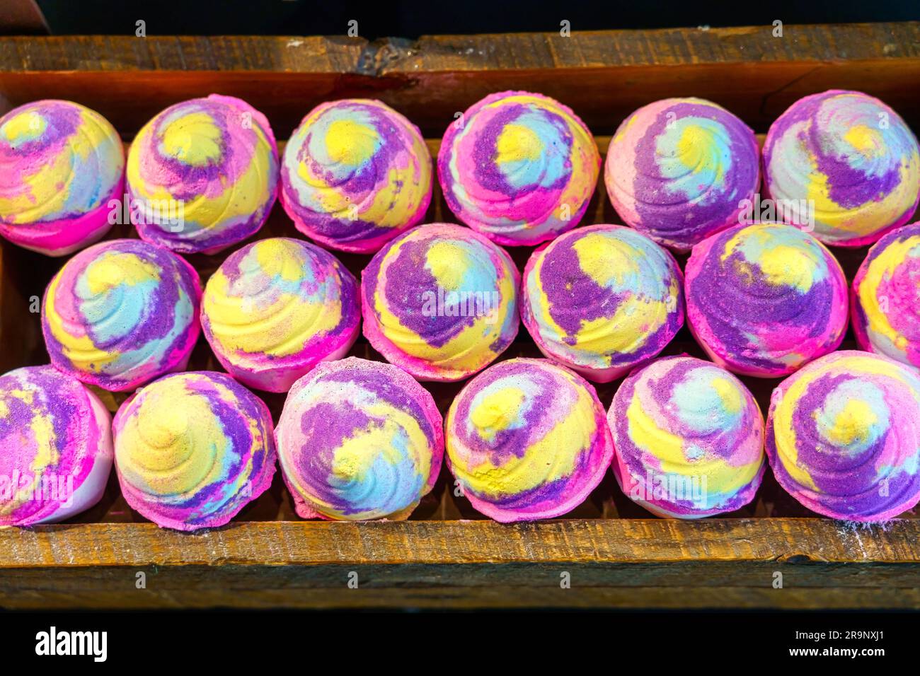 Mehrfarbige handgefertigte Seifen imitieren einen Cupcake. Sie sind in einem Ladenregal. Stockfoto