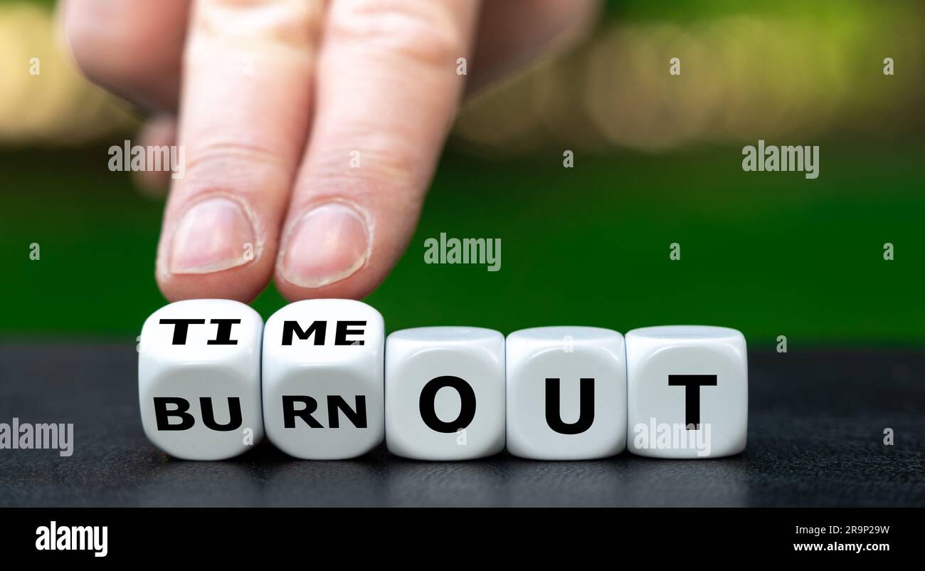 Symbol für eine Pause. Die Hand würfelt und ändert den Ausdruck „Burnout“ in „Timeout“. Stockfoto